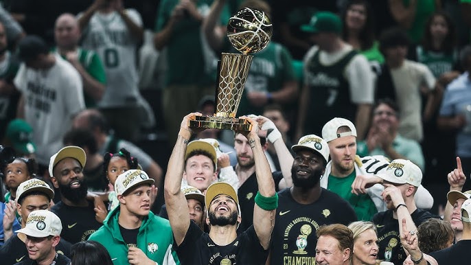 Jayson Tatum raising the NBA Trophy