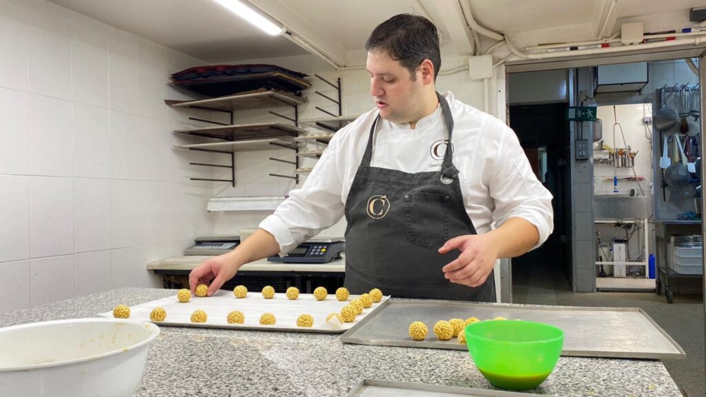 Master pastry chef Oriol Carrió preparing pine nuts panellets in the kitchen of her bakery