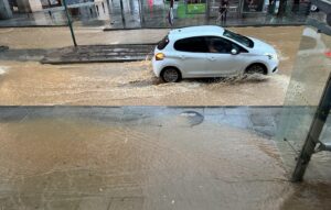 Car driving on riera basté street, which is flooded