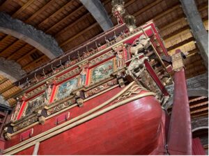 Photo of the bow of a ship being red and gold with paintings
